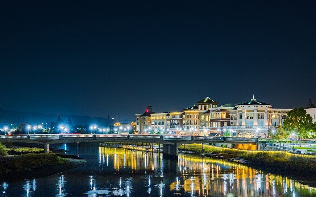 A cityscape at night with a river running through it